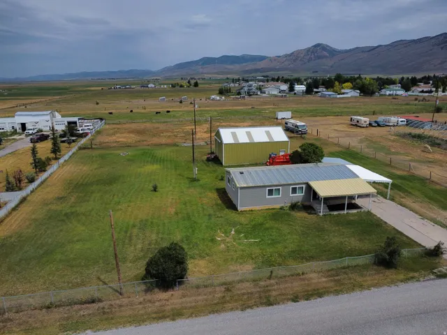 Expansive lot with a light gray exterior residence and attached carport