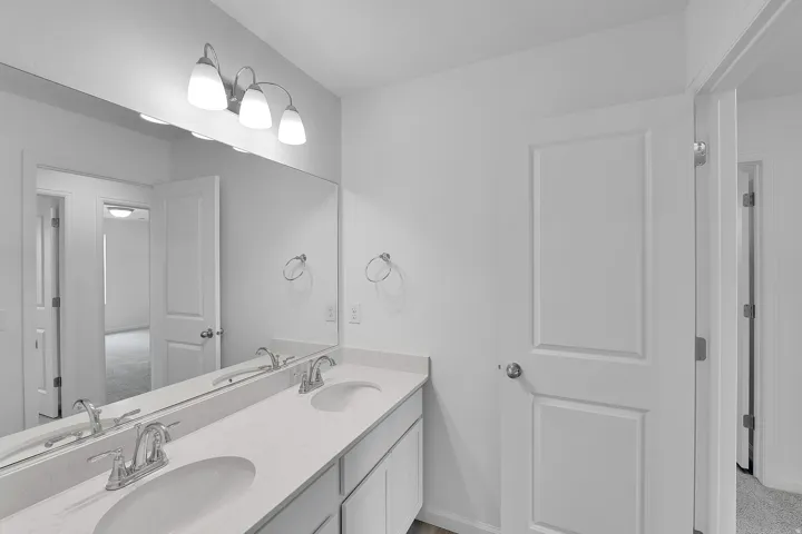 Dual vanity with undermount sinks, stone-finish countertop, and chrome fixtures
