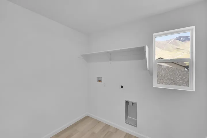 Wood-finish flooring, white walls, built-in shelving, and a window with a mountain backdrop