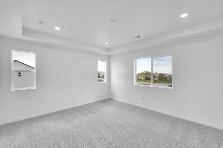 Recessed lighting, white walls, gray carpeting, and multiple windows