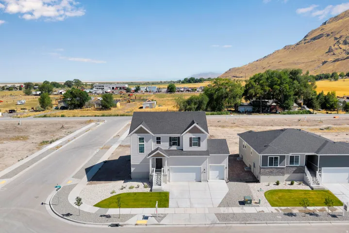 Contemporary two-story residence with a multi-gable roofline and light gray siding