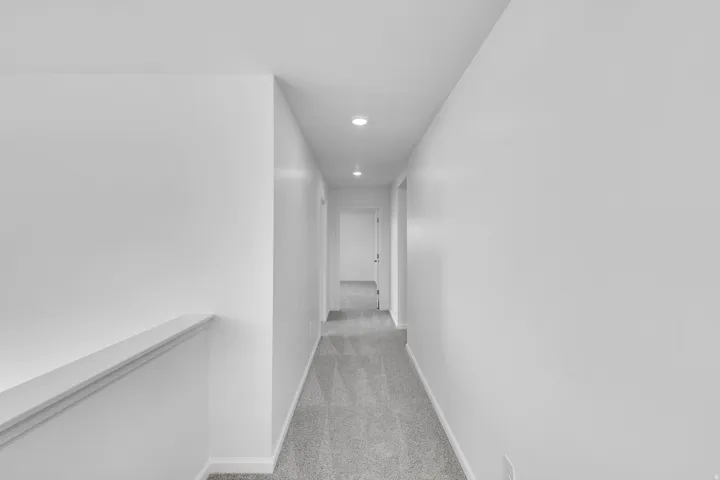 Hallway with recessed lighting and light gray carpet