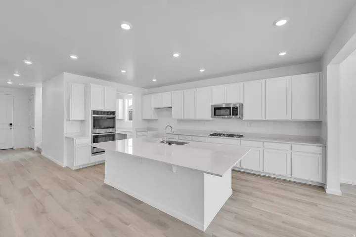 White cabinetry and light-toned wood-finish flooring