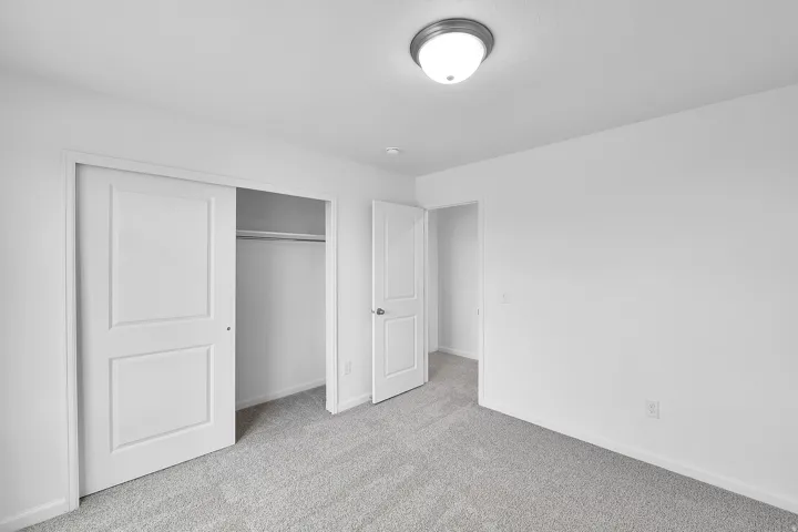 Light gray carpeting, white walls, white trim, recessed ceiling light, and white interior doors