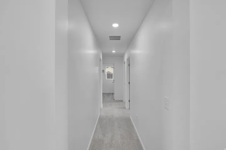 Hallway featuring recessed lighting, light-toned walls, and carpet flooring