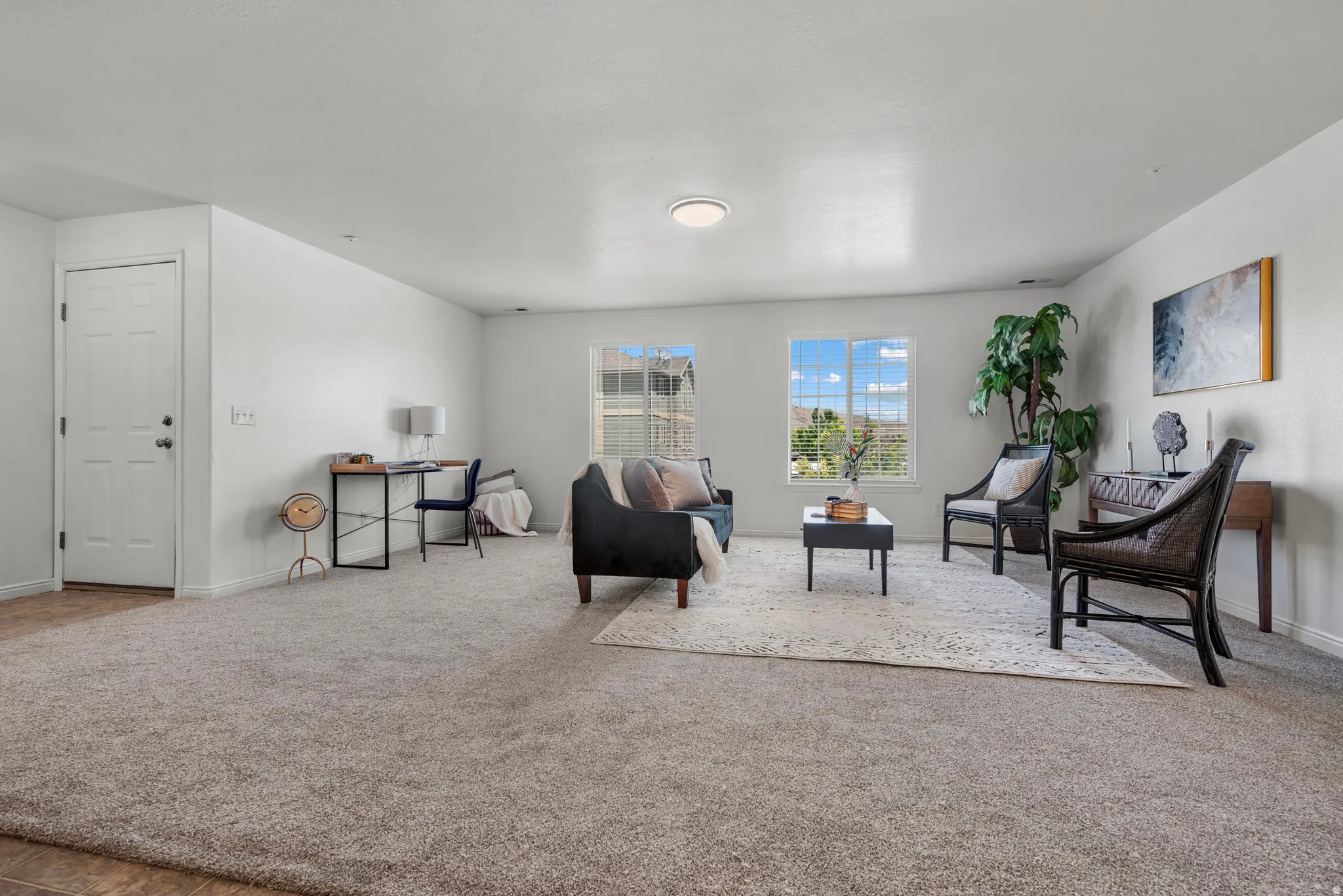 Expansive room with neutral carpeting and white walls