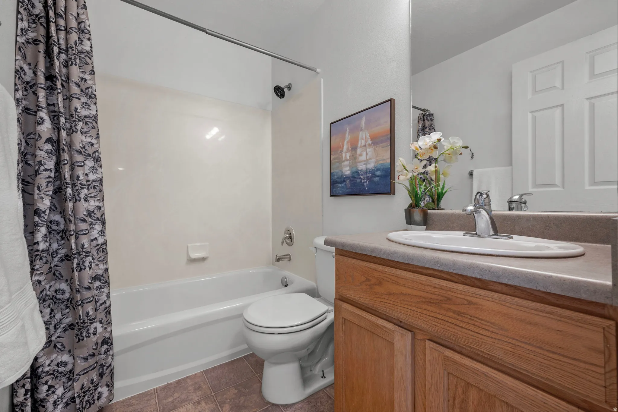 Bathroom featuring a white bathtub, shower with a dark finish showerhead, and a vanity with wood-finish cabinetry