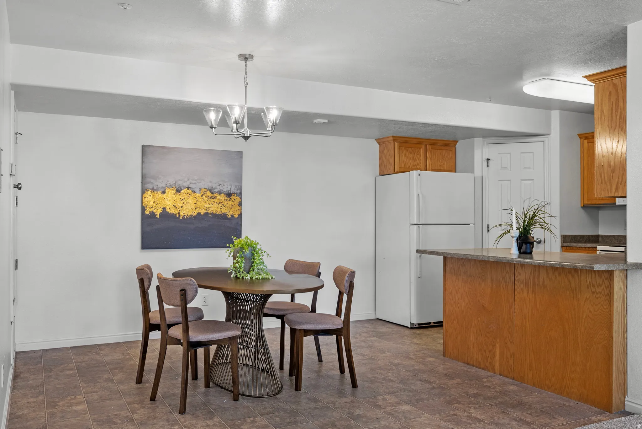 Recessed lighting, wood-finish flooring, white appliances, wood cabinetry, and a kitchen island with an extended countertop