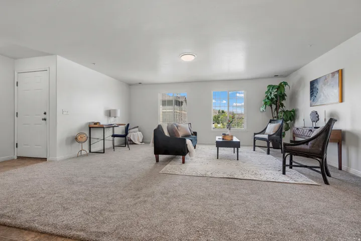 Expansive room with neutral carpeting and white walls