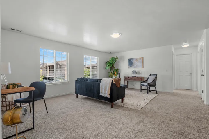 Light gray carpeting throughout, white walls, and multiple windows with blinds
