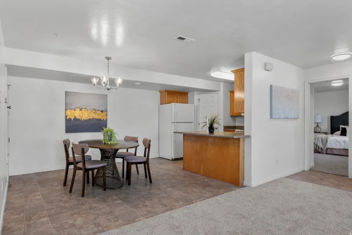 Open concept living area featuring a kitchen with wood-finish cabinetry, a breakfast bar, and a white refrigerator