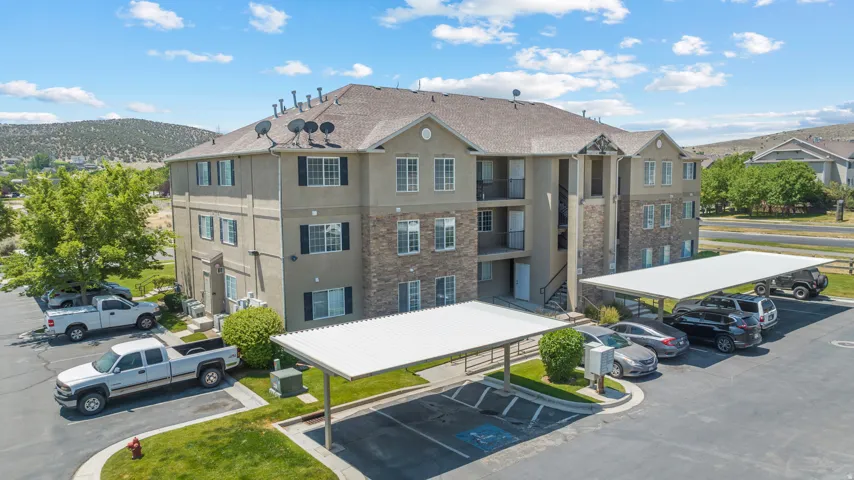 Multi-story building exterior featuring stone and stucco finishes, multiple balconies, and a pitched roof