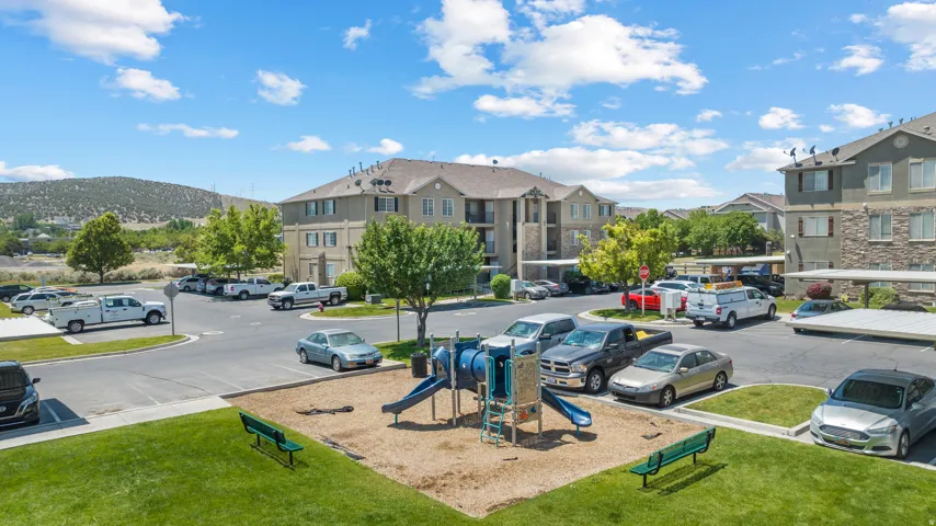 Community playground, paved parking areas, covered parking structures, and multi-story residential buildings