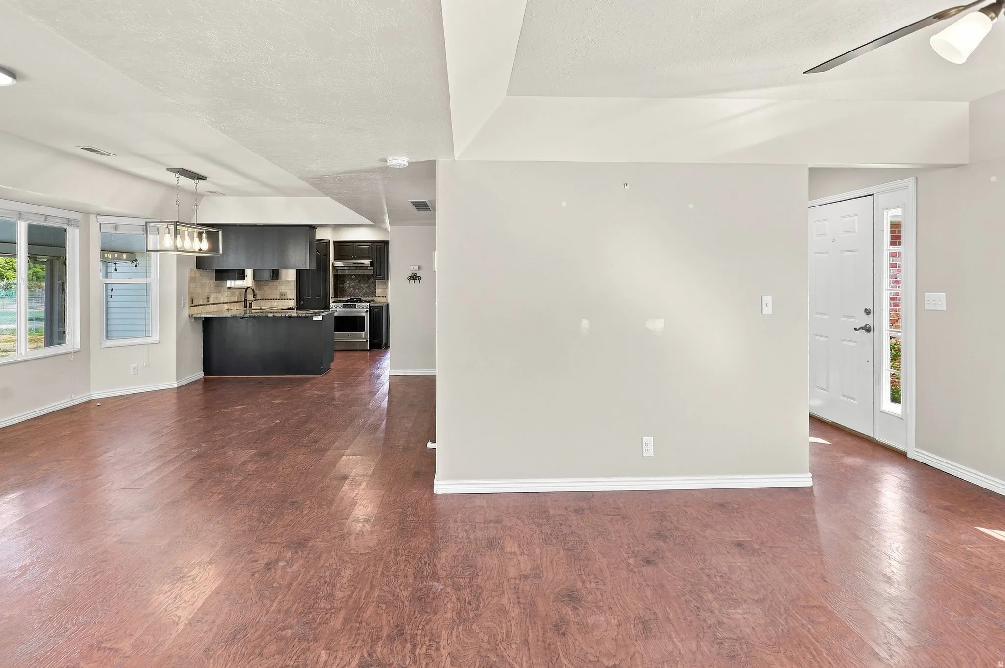 Wood-finish flooring, recessed lighting, and a modern rectangular chandelier