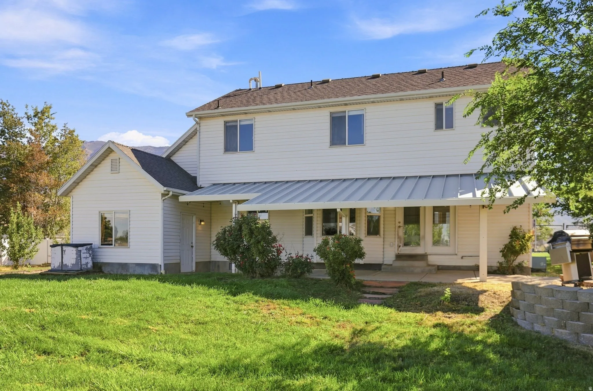 White vinyl siding exterior with a dark shingle roof