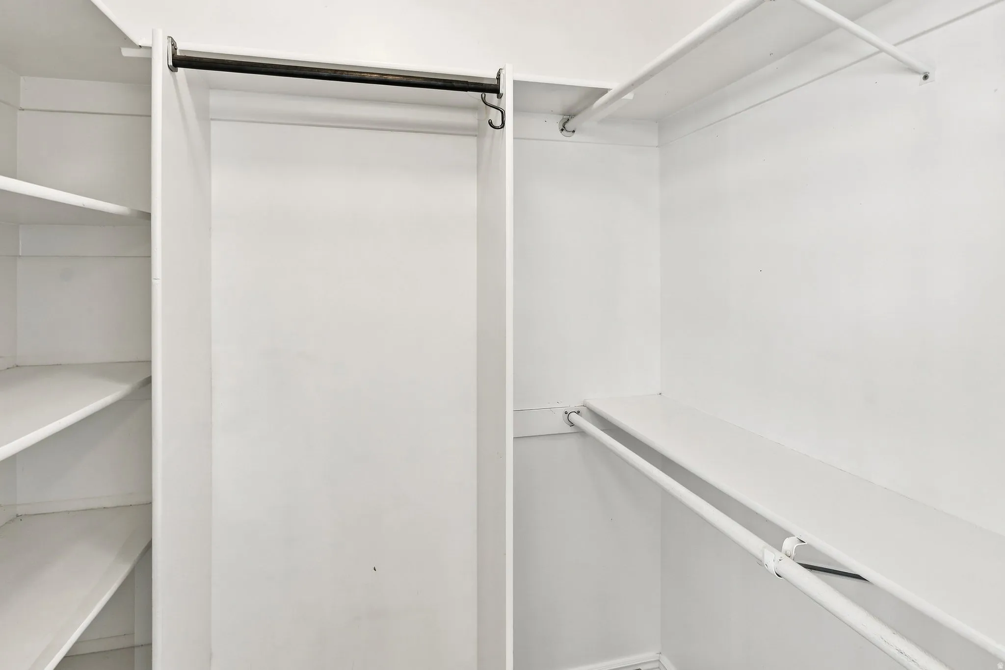 White closet system featuring multiple shelves and hanging rods