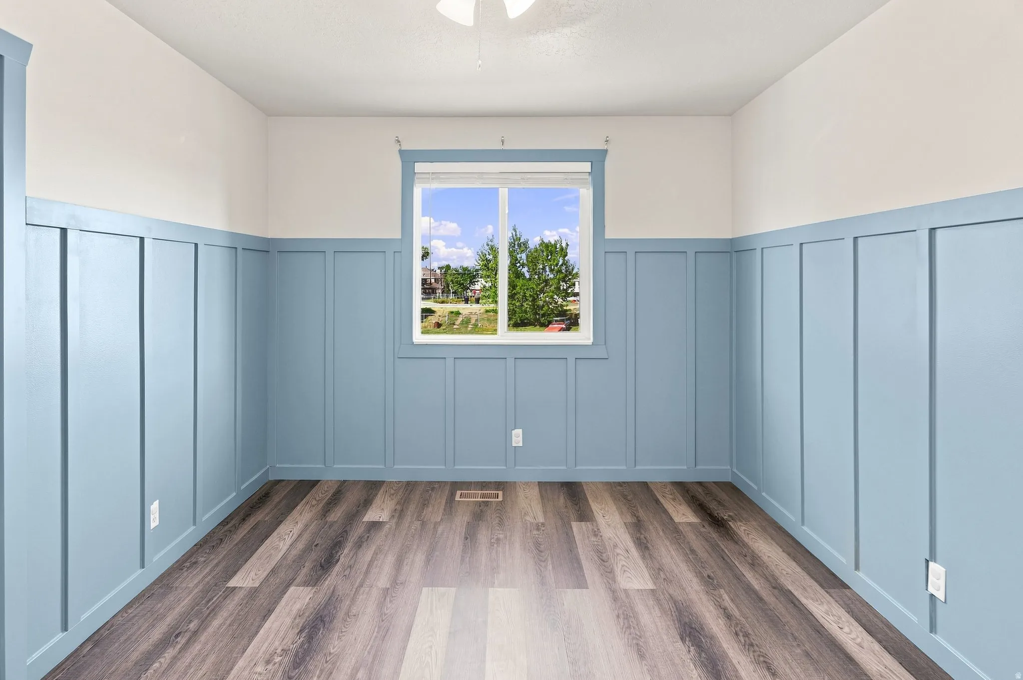Board and batten accent walls, wood-finish flooring, and a single window