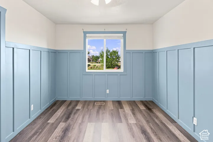 Board and batten accent walls, wood-finish flooring, and a single window