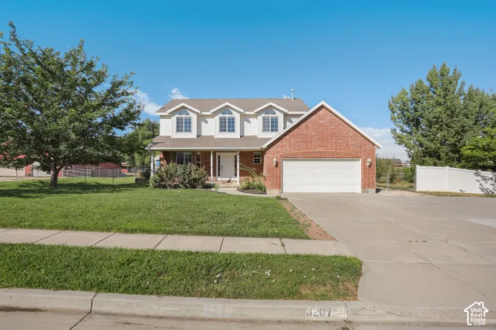 Two-story residence featuring a brick and siding exterior, an attached two-car garage, and a concrete driveway