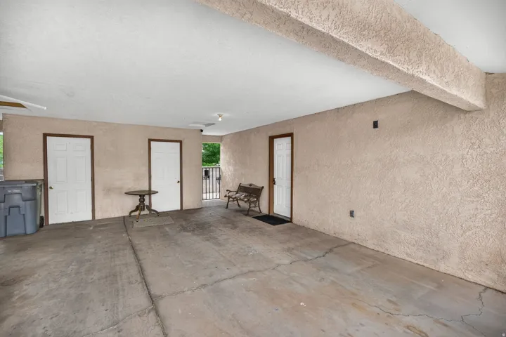 Covered concrete patio with stucco walls and multiple entry points