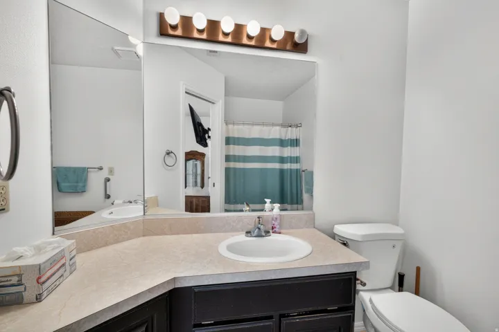 Vanity with an integrated sink, broad countertop, and wood-finish cabinetry