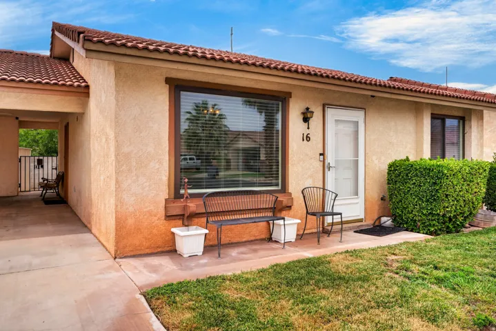 Stucco exterior featuring a red tile roof, covered entry, and front door with a full-view storm door