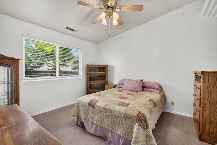 Carpeted flooring, white walls, and a ceiling fan with light fixture