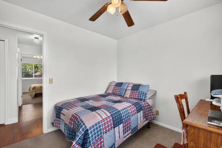 Carpeted flooring, white walls, and a ceiling fan with light fixture