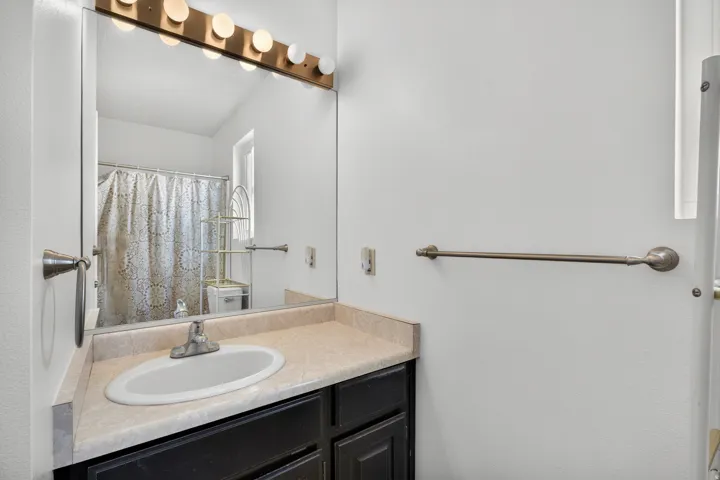 Vanity with an integrated oval sink, laminate countertop, and dark wood-finish cabinetry