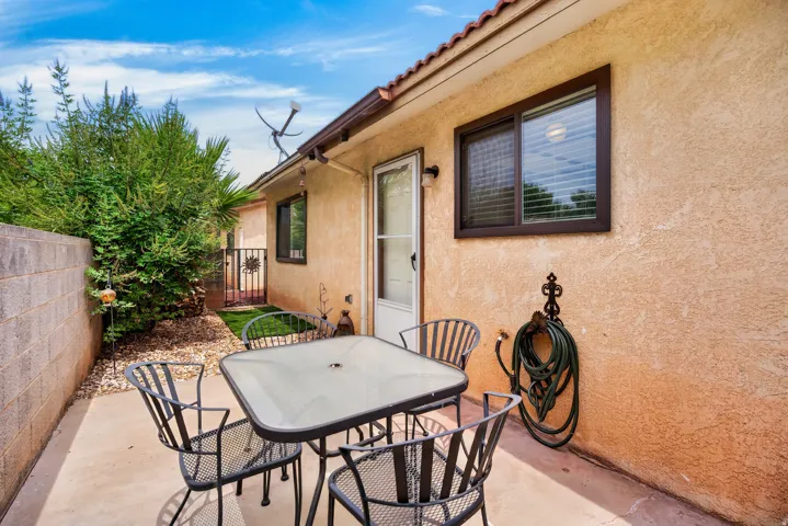Private patio area with concrete flooring, stucco exterior, and a security gate