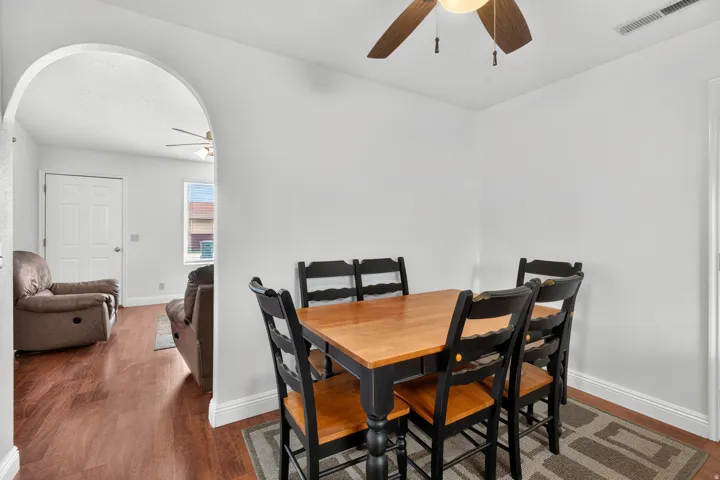 Archway opening to an additional living space with wood-finish flooring