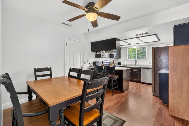 Hardwood-finish flooring, recessed lighting, ceiling fan with integrated light fixture, kitchen island with built-in storage, and stainless steel appliances