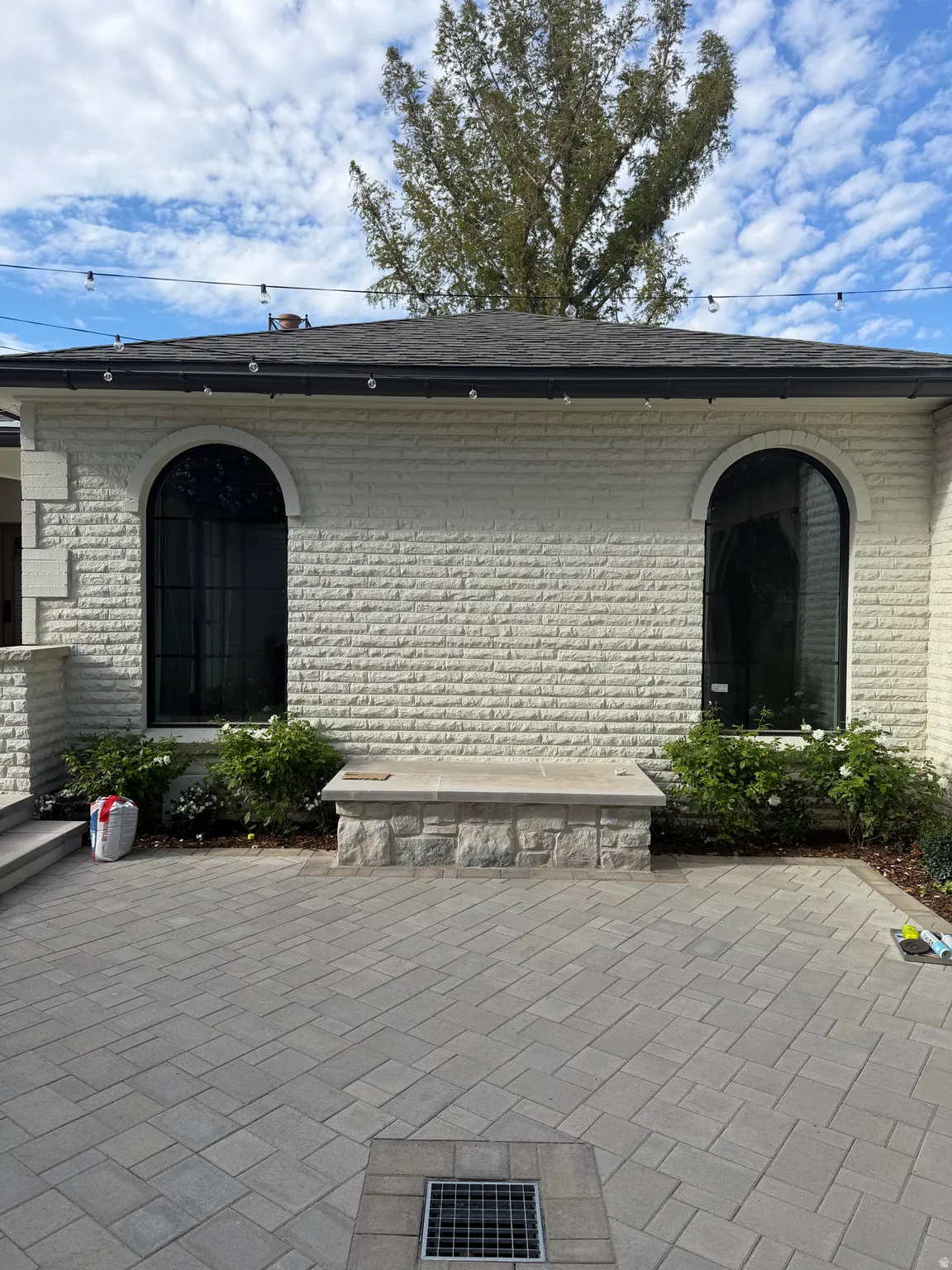 Exterior with a white stone facade, arched windows, and a dark shingle roof