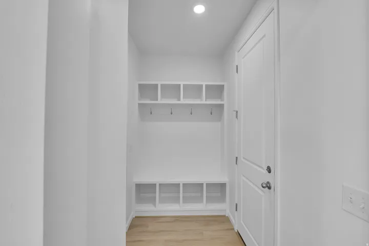 Built-in mudroom storage with open cubbies, integrated hooks, and a bench
