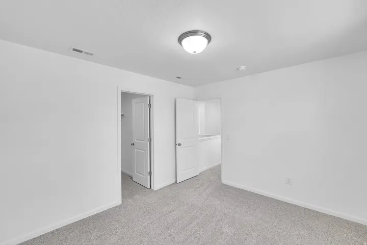 Neutral gray carpeting and white painted walls