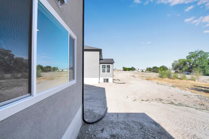 Stucco exterior with white-framed windows and a downspout