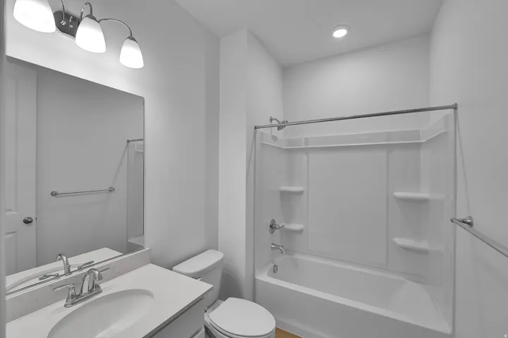 White vanity with a single basin, chrome faucet, and quartz-finish countertop
