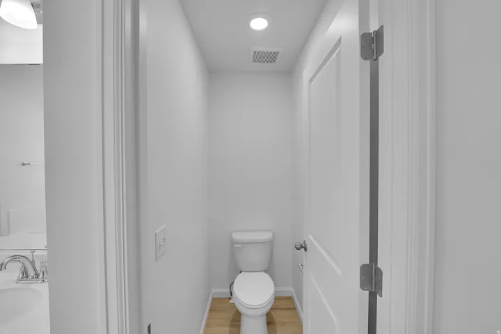 Recessed lighting, wood-finish flooring, and white paneled door