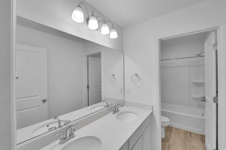 Double vanity with dual undermount sinks, chrome fixtures, and a large mirror