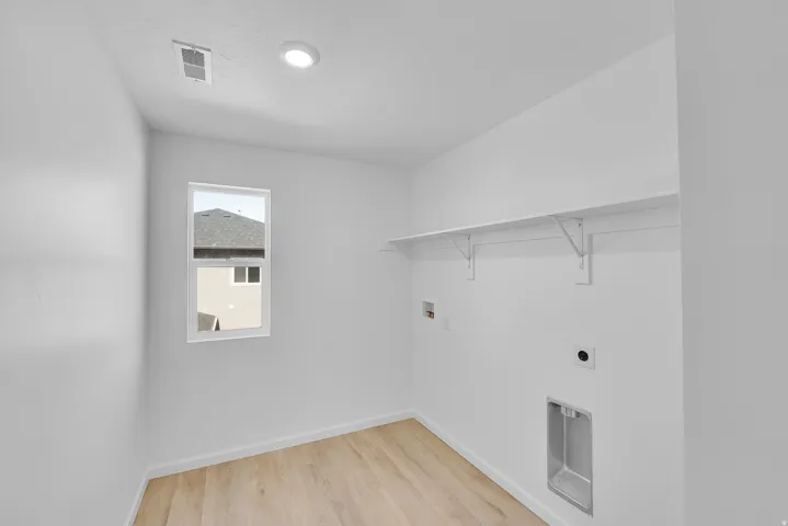Recessed lighting, wood-finish flooring, single window, wall-mounted shelving, and appliance hookups