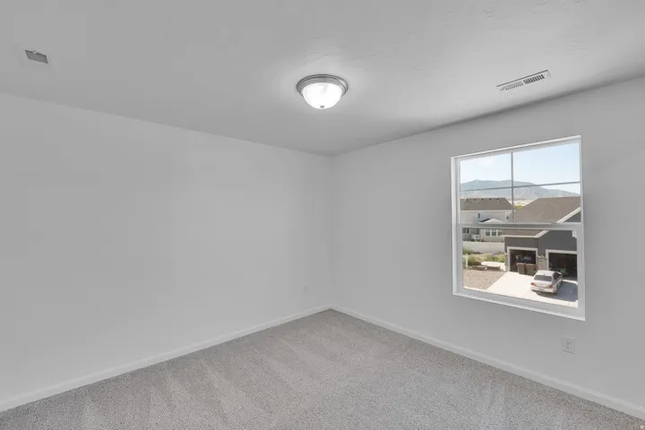 Recessed lighting, light gray carpeting, neutral wall color, and a window with mountain scenery