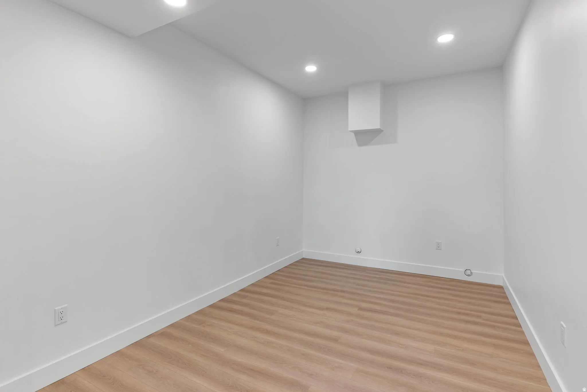 Recessed lighting, light wood-finish flooring, white walls, and a white ceiling