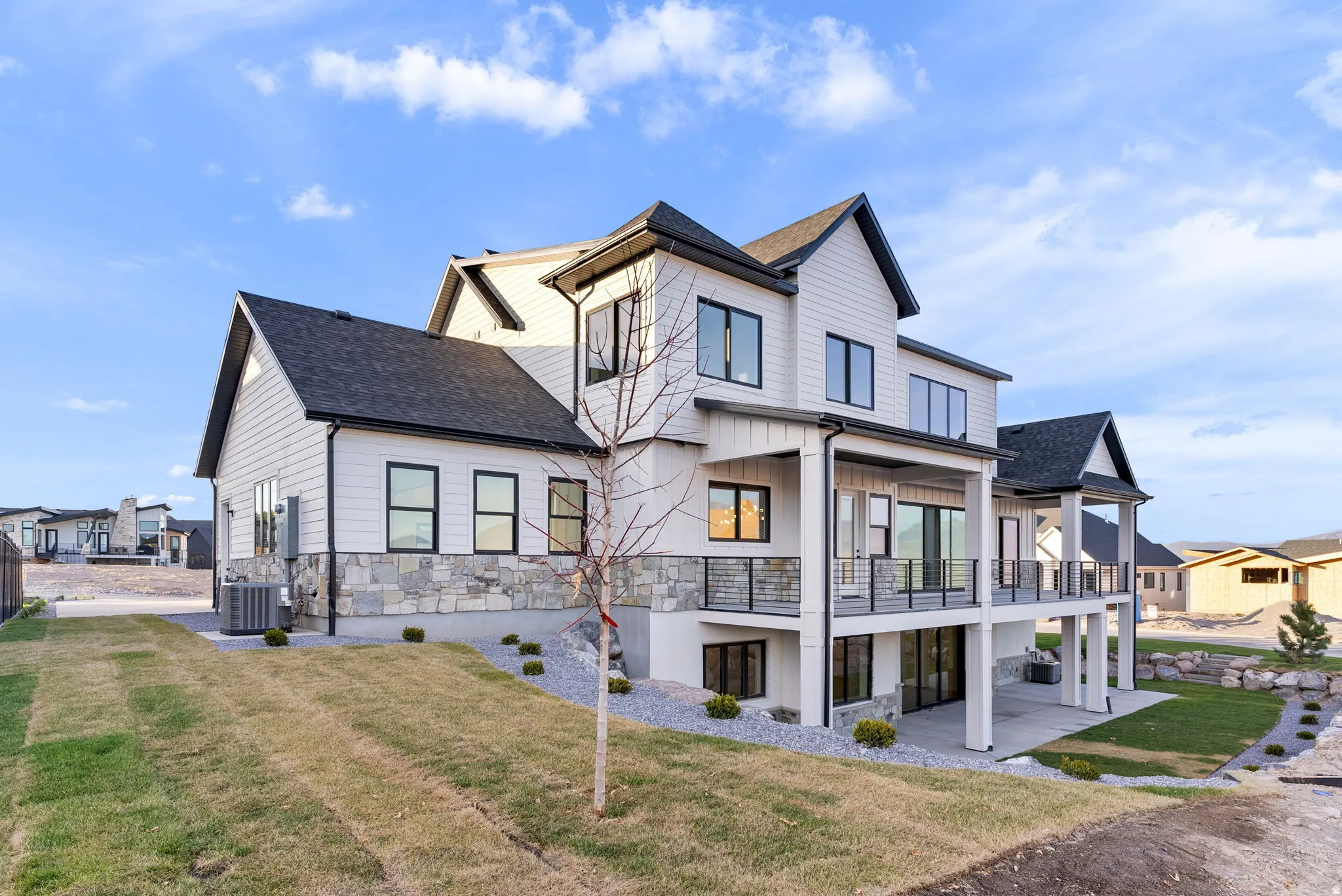 Multi-level exterior featuring white siding and stone cladding