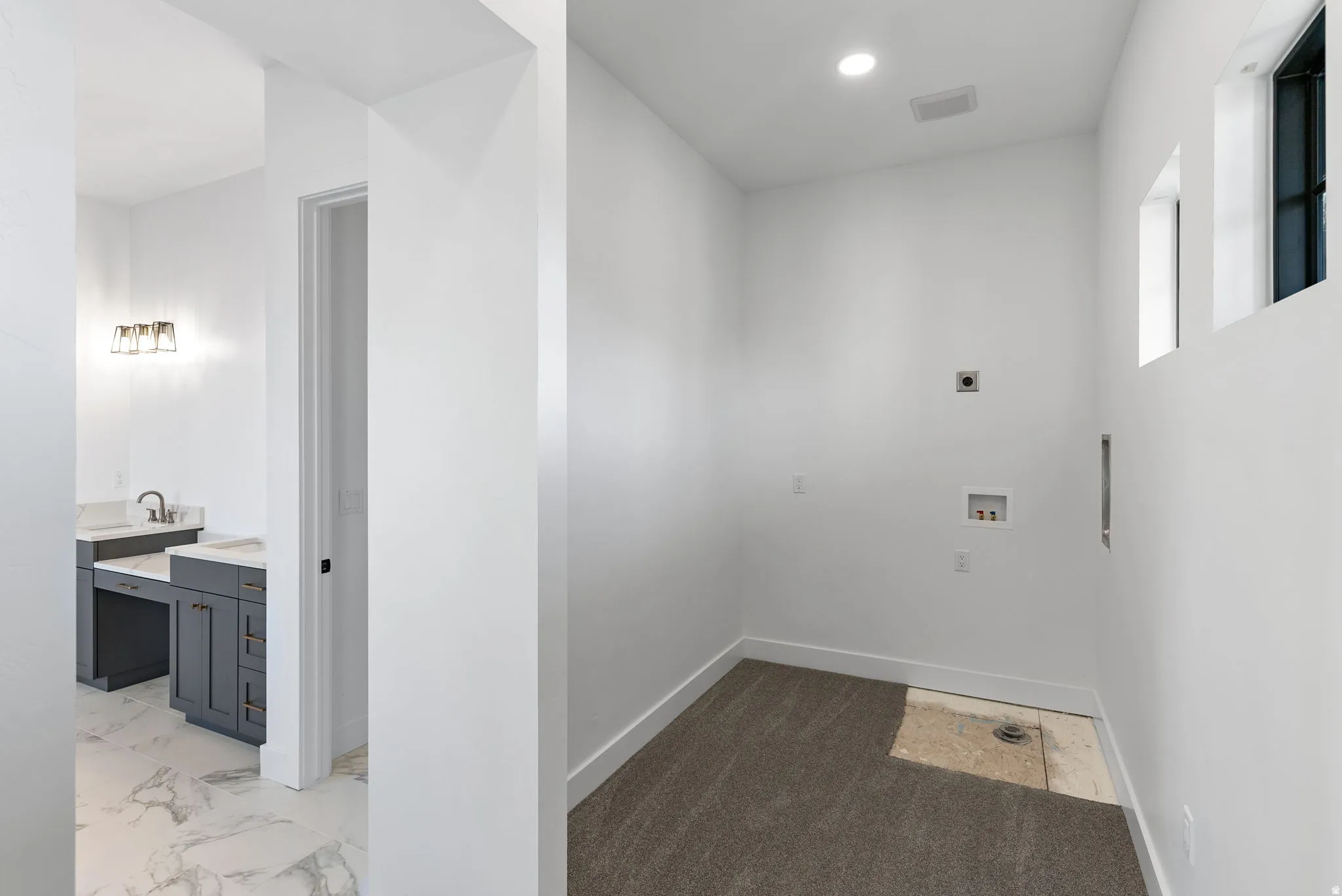 Laundry area with partial carpeting and recessed lighting