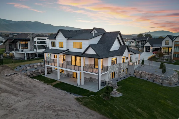 Modern exterior featuring white siding, stone veneer accents, and a dark shingle roof