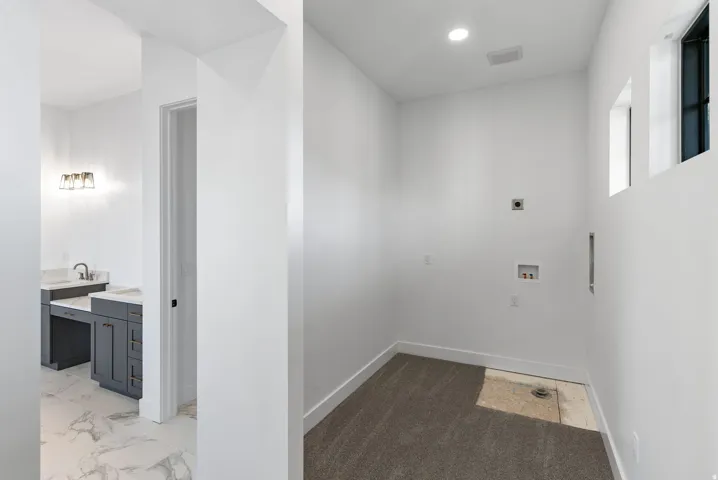 Laundry area with partial carpeting and recessed lighting