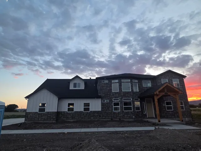 Stone and vertical siding exterior with a dark roof