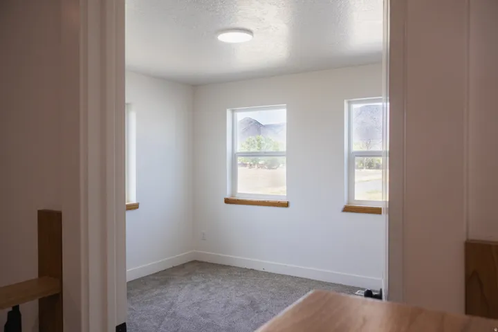 Room with multiple windows, recessed ceiling light, and neutral-toned carpeting