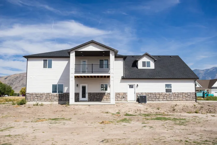 Two-story exterior with white siding and a stone-finish foundation