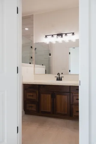 Wood-finish vanity with an integrated sink and matte black faucet